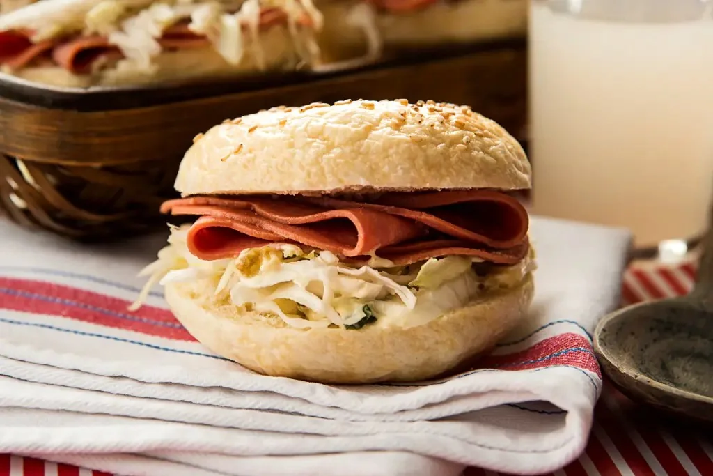 Pastrami en bagel con pasas de uva y perejil